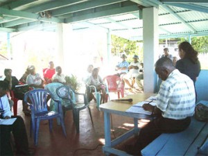 Residents listen to Minister of Amerindian Affairs, Pauline Sukhai (standing, right) at Tuschen during a cabinet outreach yesterday.  