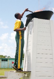 Guyana&#8217;s IGG 100 &amp; 200 metres champion Treiston Joseph lighting the Games torch (Orlando Charles photo) 